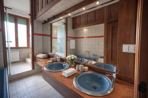 a bathroom with two sinks and a large mirror at Villa Elettra in Pisa