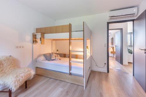 a bedroom with a bunk bed and a chair at Nebbiu - 25km de Bastia in Murato
