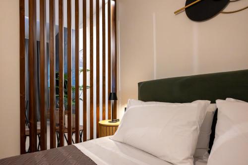 a bedroom with a bed with a green headboard at Olea Blue Suite in Stalís