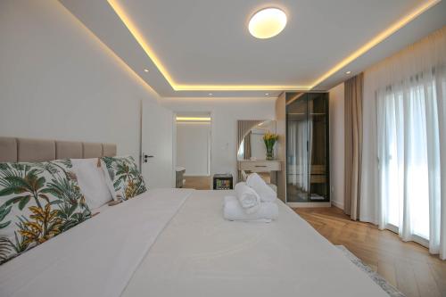 a bedroom with a large white bed with towels on it at Murati Lake View Hotel in Tirana