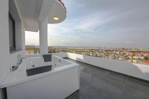 a white bathroom with a view of a city at Murati Lake View Hotel in Tirana