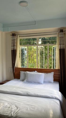 a large bed in a bedroom with a window at Spring Grove B&B in Jowai