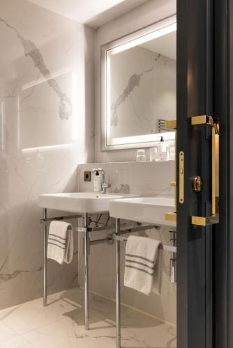 une salle de bains avec un lavabo et un miroir dans l'établissement Normandy Le Chantier, à Paris