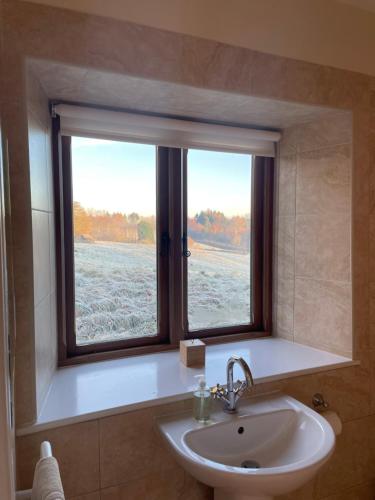 a bathroom with a sink and a window at Cool Contours Venue in Eydon