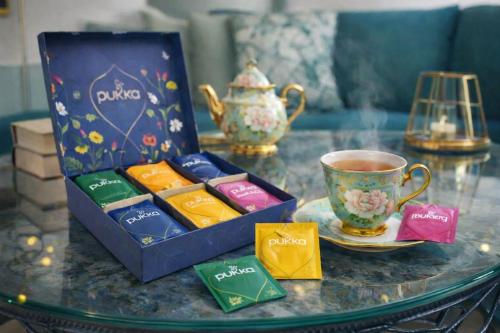 a table with a box of chocolates and a cup of tea at The Kensington Luxe Residence - Elite Location in London