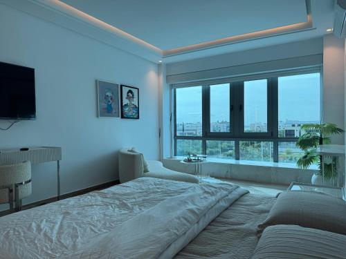 a bedroom with a large bed and a large window at SKYLINE SUITES Tunisia in Tunis