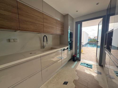 a kitchen with white cabinets and a sliding glass door at SKYLINE SUITES Tunisia in Tunis