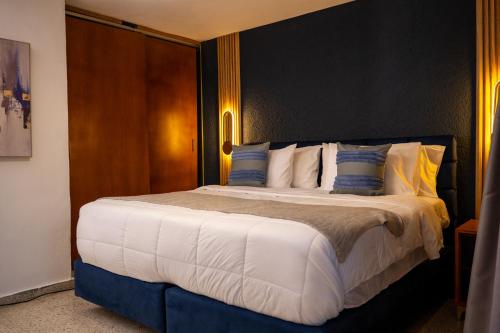 a bedroom with a large bed with blue and white pillows at Tribe Boutique Resort by Mega Stays in Guayacanes