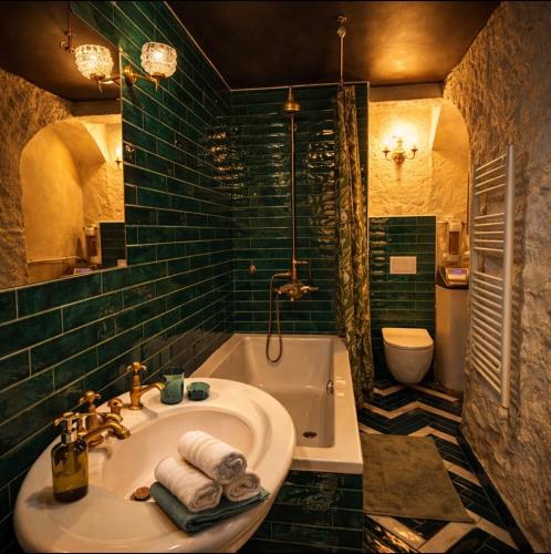 a bathroom with a tub and a sink and a toilet at L'écrin de la Chartreuse in Villeneuve-lès-Avignon