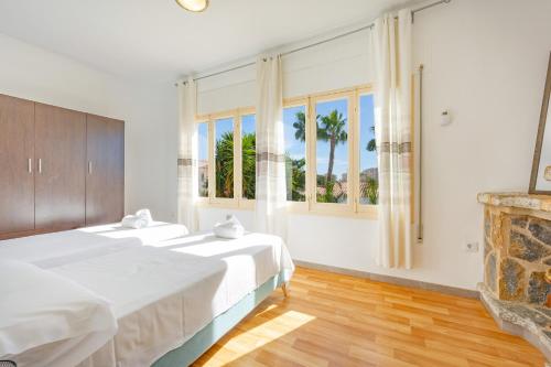 a bedroom with two beds and a fireplace at Villa Cronos - PlusHolidays in Ifach