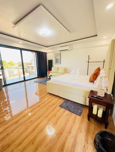 a bedroom with a bed and a living room at The Penthouse With Outdoor Jacuzzi Private Rooftop Solar Powered Energy in Puerto Princesa City