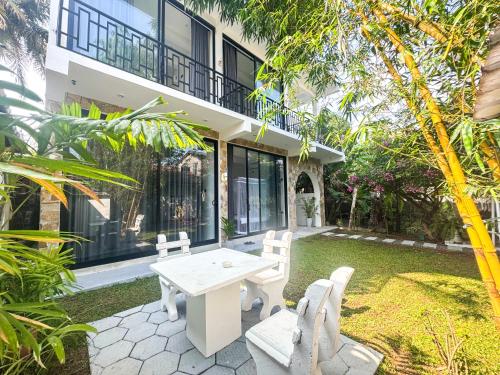 a patio with a table and chairs in front of a building at SIlvas Surf Home in Weligama