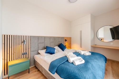 a bedroom with a large bed with blue pillows at Akces APARTAMENTY KASPROWICZA 20C- BASEN, SAUNY, JACUZZI, SIŁOWNIA W CENIE - SCHWIMMBAD, SAUNEN, JACUZZI, FITNESSSTUDIO IM PREIS in Kołobrzeg