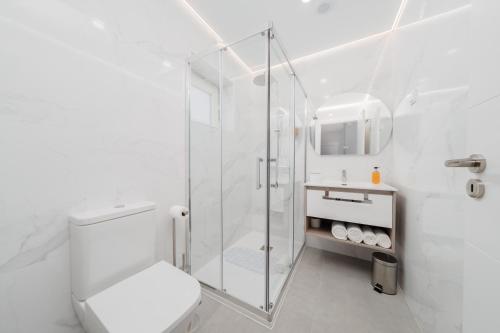 a white bathroom with a shower and a toilet at Guesthouse Solar do Mar in Silveira
