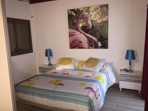 a bedroom with a bed with a painting on the wall at Casa Corralejo a 40 m playa in Corralejo