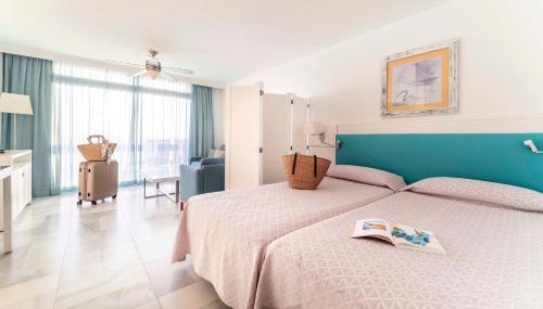a bedroom with a bed with a book on it at Ona Palm Beach in Playa de las Americas