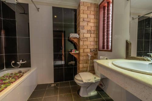 a bathroom with a sink and a toilet and a tub at Dara Panha Sak Guesthouse in Siem Reap