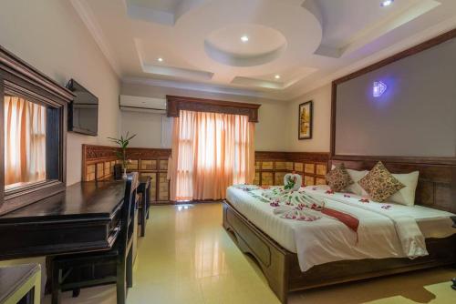 a bedroom with a large bed and a piano at Dara Panha Sak Guesthouse in Siem Reap