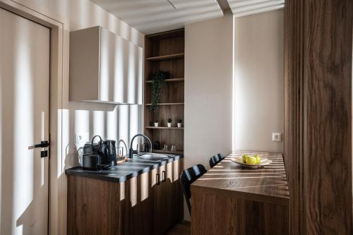 a kitchen with a sink and a counter with chairs at Bedspot Heraklion in Heraklio