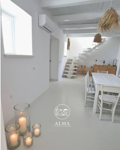 a white room with candles on the floor and a table at Alma Capodimonte Lake chalet in Capodimonte