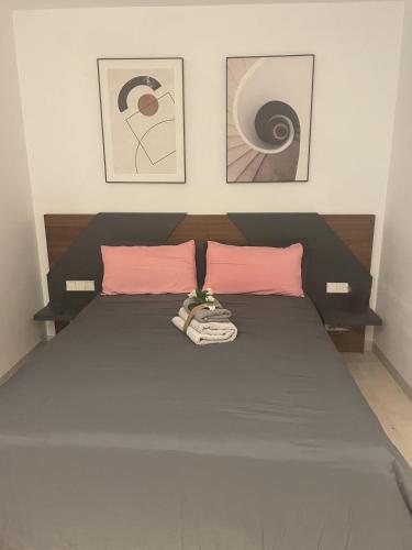 a bedroom with a bed with two pink pillows at Santa Rosalia Lake & Life resort in Torre-Pacheco