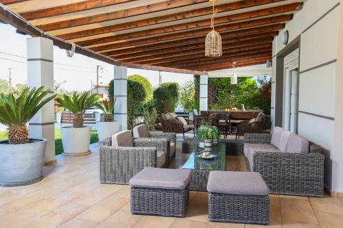 an outdoor patio with wicker chairs and tables at Villa Beta 2 - 3min walk to Elephant and Mako in Pefkochori