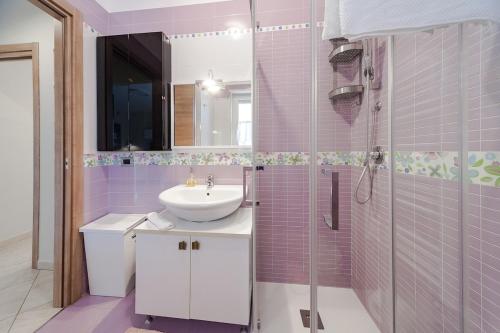 a pink bathroom with a sink and a shower at Brezza di Mare Apartment in Scanzano