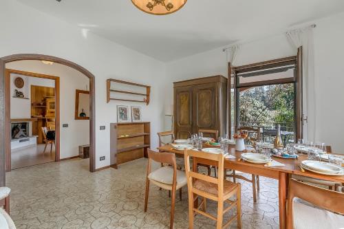 a dining room with a wooden table and chairs at Villa Eva: Leggiuno 5-Bed Villa for Families & Groups (Sleeps 10) - Happy Rentals in Leggiuno