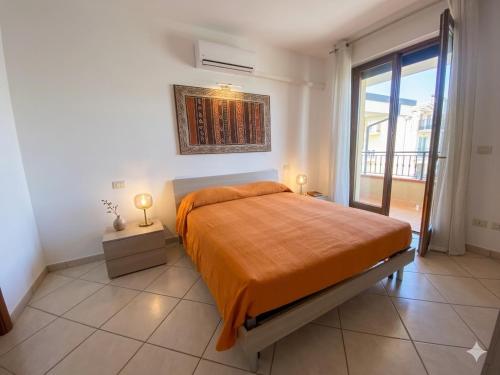 a bedroom with a bed with an orange blanket at TRIESTE - Premium Villas in Giulianova