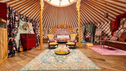 a room with a yurt with a couch and chairs at 2 CUORI E 1 YURTA Glamping in Tuscany - Adults Only in Asciano