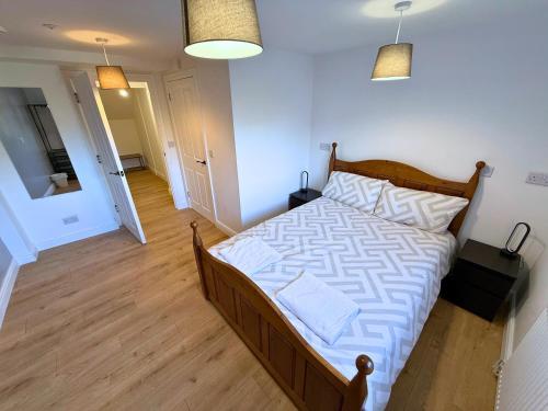 a bedroom with a large bed with a wooden floor at New 3 Bedroom Apartment Next to Station in Chepstow
