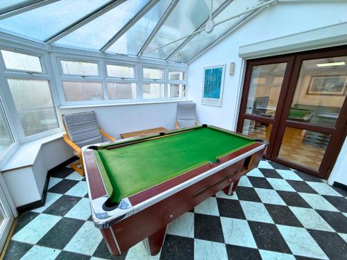 a pool table in a room with two chairs at New 4 Bed House Sleeps up to 8 People in Chepstow