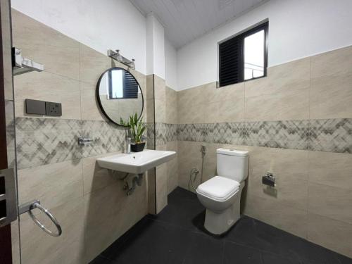 a bathroom with a toilet and a sink and a mirror at Lipton View Inn near Ella & Haputhale in Bandarawela