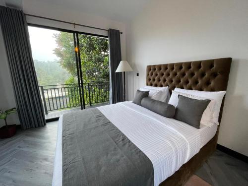 a bedroom with a large bed with a large window at Lipton View Inn near Ella & Haputhale in Bandarawela