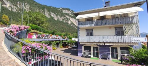 a building with flowers on the side of a mountain at Apartments Giovannini in Fai della Paganella