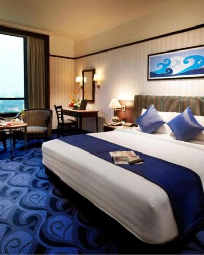 a hotel room with a large bed and a desk at Hotel Anantha Suites in Sitam Petta