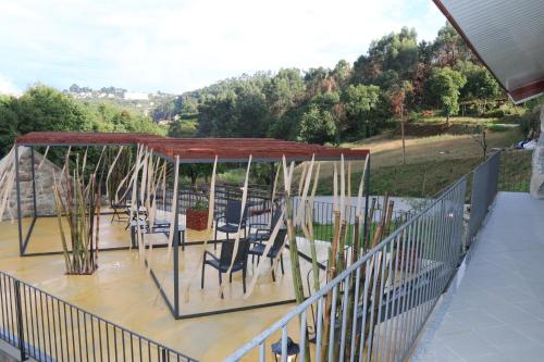 a deck with chairs and tables and a canopy at Quinta da Costa in Lixa