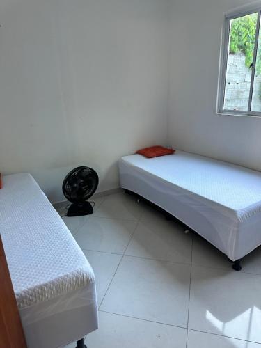 a room with two beds and a window at Casa Verano dHebron in Camaçari