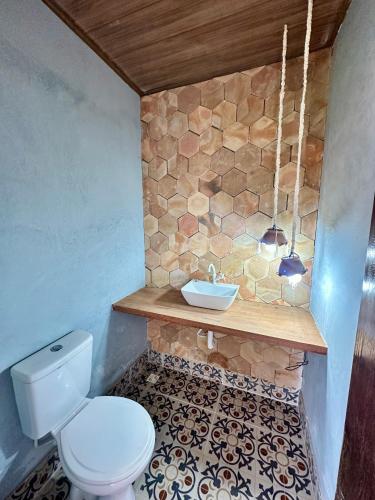 a bathroom with a toilet and a sink at Casa Verano dHebron in Camaçari