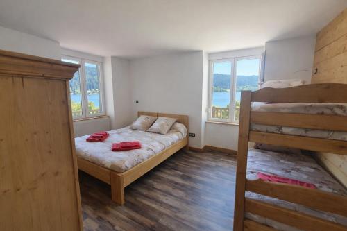 a bedroom with two bunk beds and two windows at Domusigua in Gérardmer