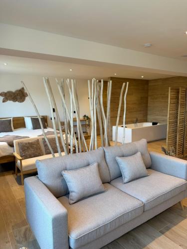 a living room with a couch and a bed at Le Loft des Crêtes in Dinant