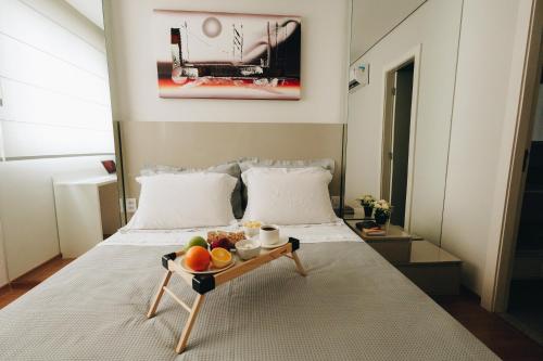 a bed with a tray of fruit on it at LRFlat 3 - Flat para pessoas exigentes com requinte e conforto próximo de tudo! Garagem e portaria 24h in Montes Claros