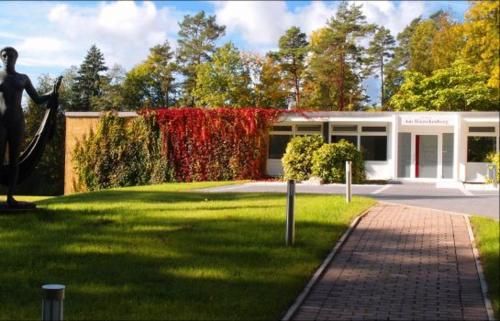a building with a statue of a woman in the grass at Gästehaus am Räuschenberg in Höxter