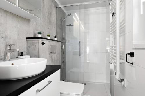 a white bathroom with a sink and a shower at First Camp Lunde - Telemark in Lunde