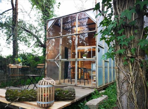 a glass house in a garden with a tree at Green Box - be in nature with direct train to Porto in Valongo