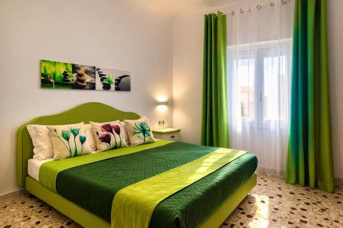a bedroom with a green bed and a window at Floral Holiday in Minori