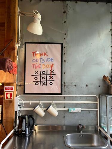 a sign on the wall above a kitchen sink at Green Box - be in nature with direct train to Porto in Valongo