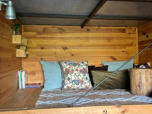 a bed in a room with a wooden wall at Green Box - be in nature with direct train to Porto in Valongo