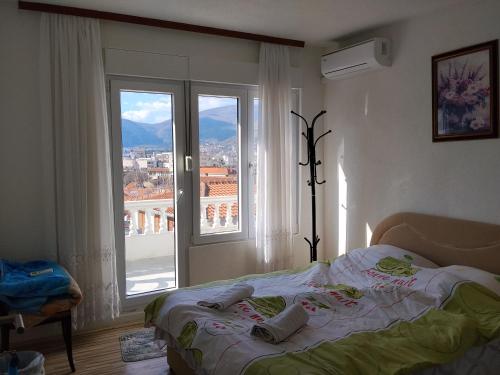 a bedroom with a bed in front of a window at Guest House LEA in Mostar