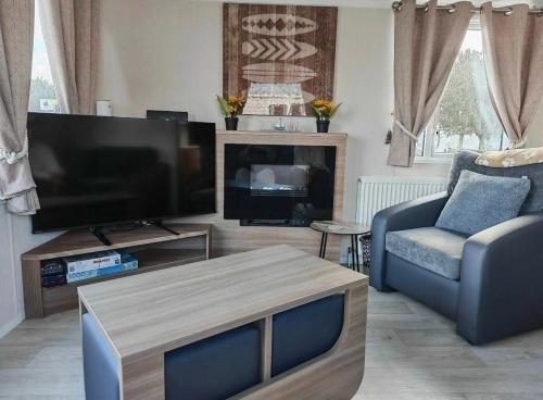 a living room with a flat screen tv and a couch at 9 Fairway, Hopton Holiday Park - Three bedroom, sleeps 6, kitchen, lounge and dining area - Minimum 3 night breaks in Hopton on Sea